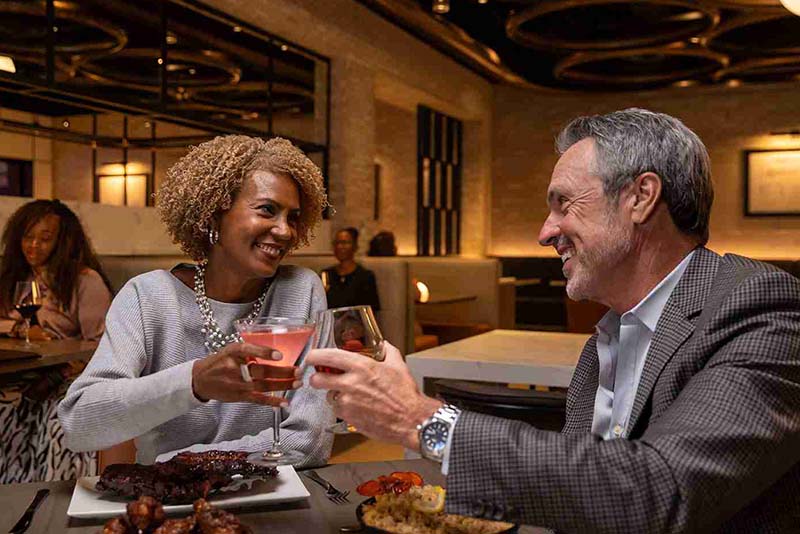 Couple cheers-ing wine glasses at 1609